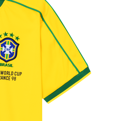 Detailansicht der rechten Vorderseite des gelben Heim-Trikots der brasilianischen Nationalmannschaft zur Fußball-WM 1998 mit Brasilien-Logo, grün gesticktem Schriftzug BRASIL, vier Sternen für vier gewonnene Weltmeisterschaften und Fifa World Cup France 98-Patch